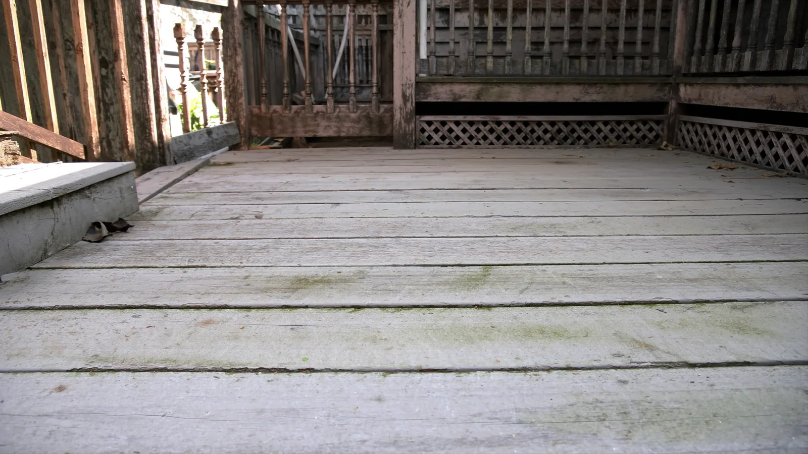 Aging 1990s Renton deck before replacement — rotted wood boards and failing railing