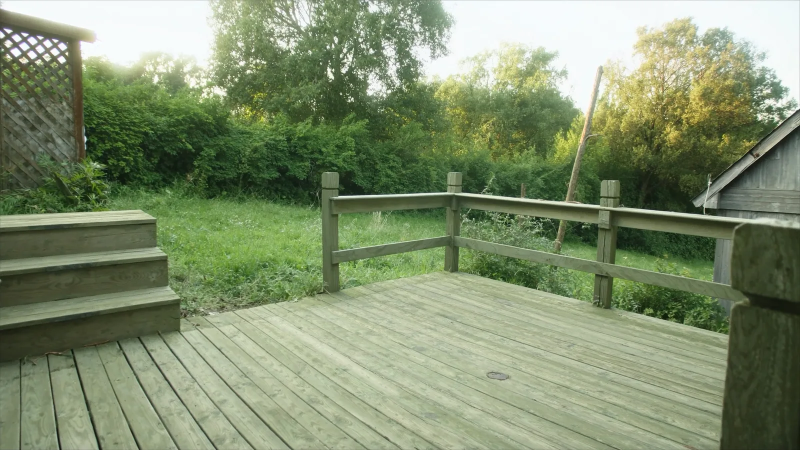 Worn Tacoma deck before restoration — grayed cedar boards and loose railing
